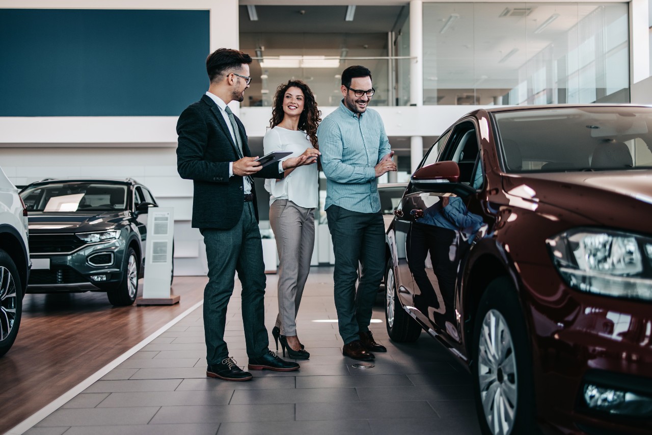 a group of people standing next to a car