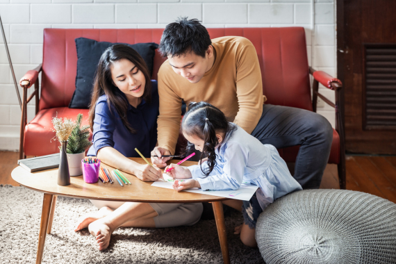 a man and a woman sitting at a table with a child and a woman