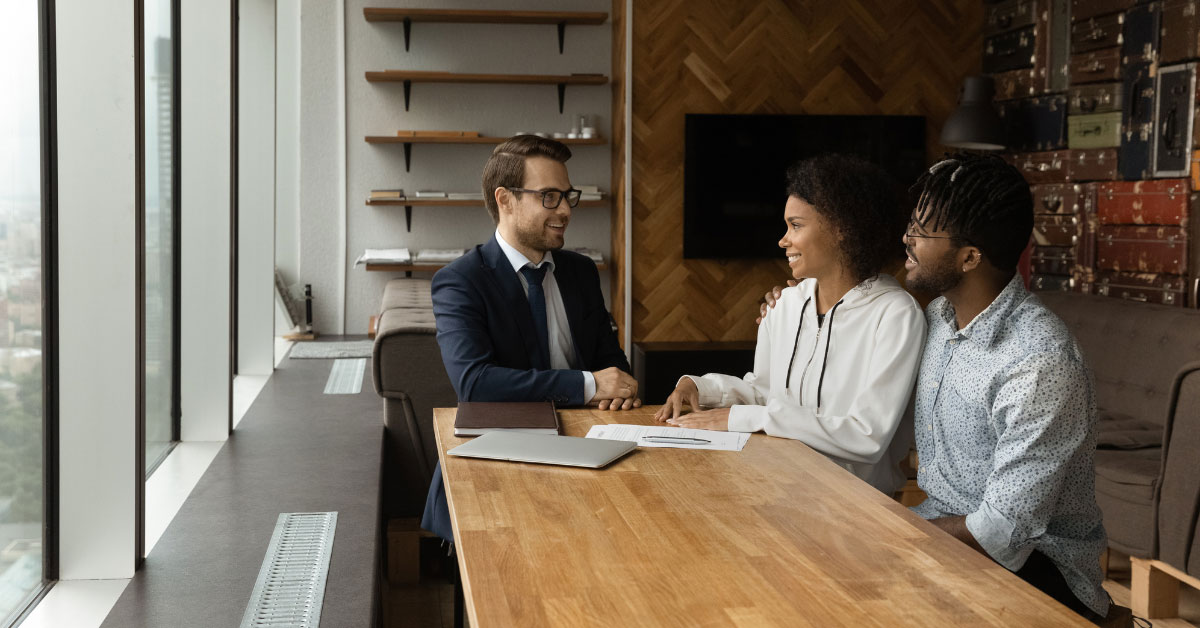 a group of people sitting at a table with documents